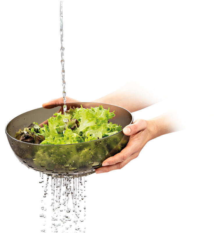 Salade verte lavée sous l'eau dans un bol 3 en 1