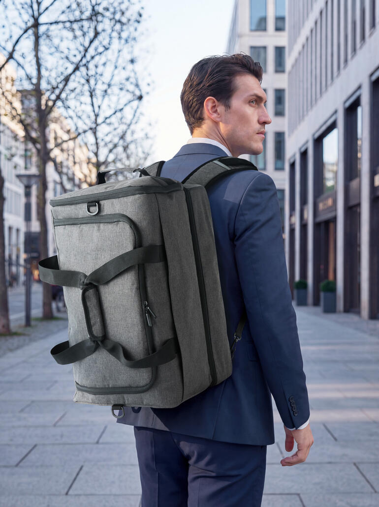 Homme portant un sac tout-en-un gris 2-en-1 sur le dos dans la ville.