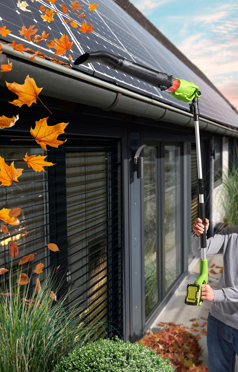 Souffleur à feuilles télescopique sans fil nettoie les feuilles d'un toit.
