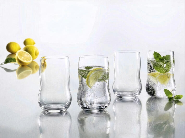 Quatre verres Holmegaard avec des tranches de citron vert sur une table.