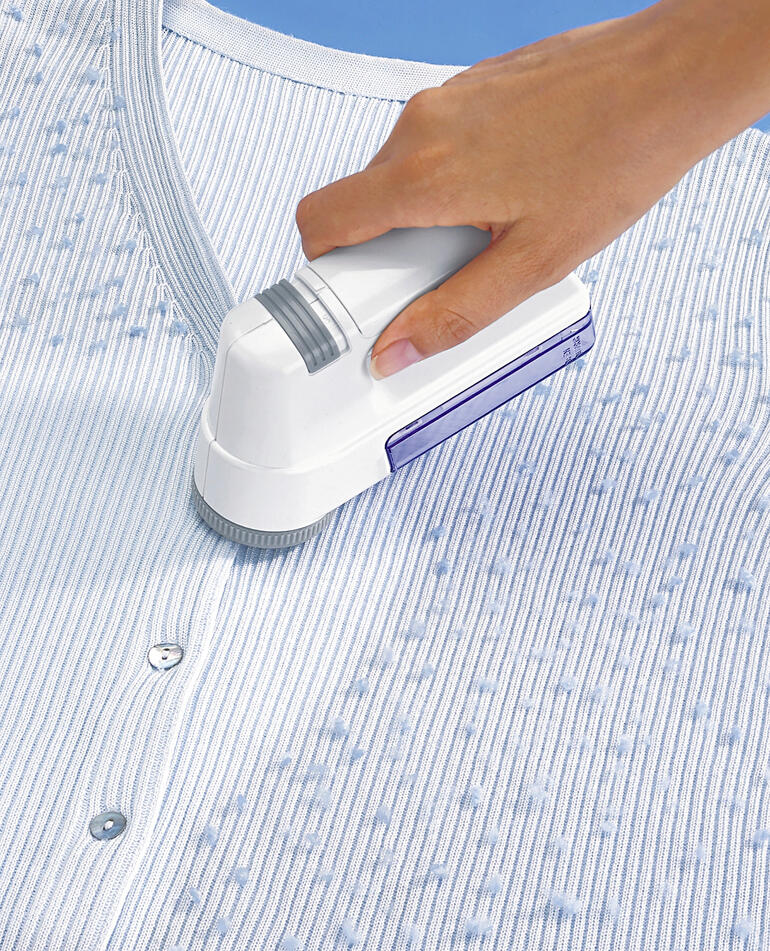 Rasoir à laine utilisé pour enlever les peluches d'un pull rayé.