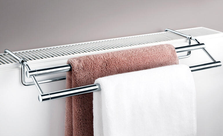 Sèche-serviettes monté au-dessus d'un radiateur avec des serviettes.