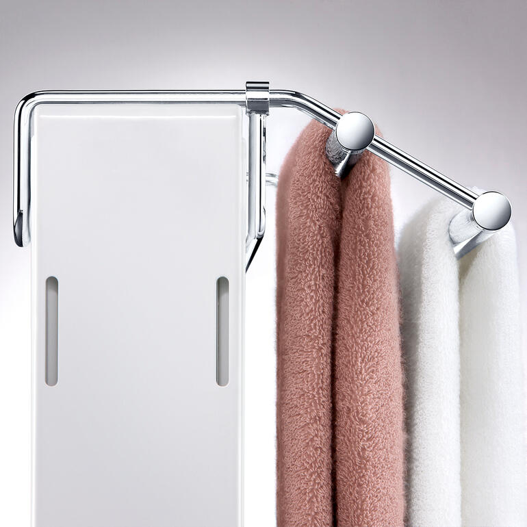 Avec son arceau réglable sans palier, le support s’adapte parfaitement à la forme du radiateur. Vue détaillée du sèche-serviettes avec des serviettes accrochées.