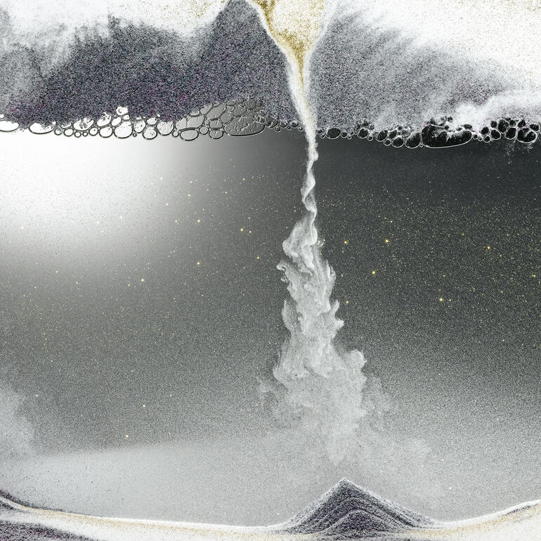 Le sable fin comme de la poussière se fraie résolument son chemin dans la couche de bulles d’air. Gros plan d'une image de sable avec un tourbillon de sable.
