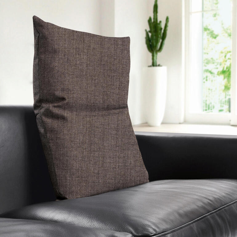 Parfaites pour les canapés et fauteuils actuels, les housses à grosses mailles dans les tons gris clair, gris foncé et marron. Coussin de dos marron sur un canapé noir.