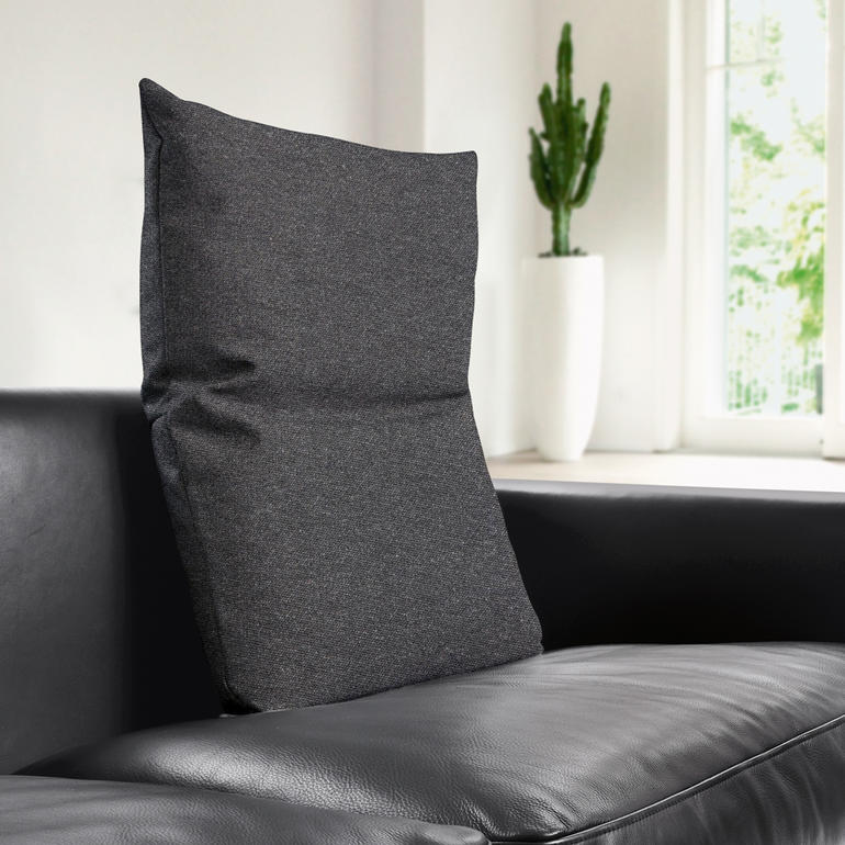 Coussin de dos anthracite sur un canapé noir.