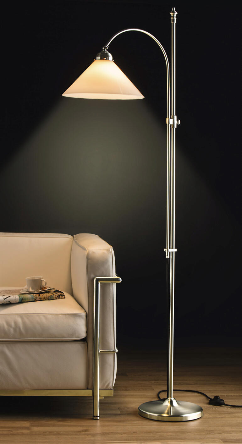 Lampadaire en laiton berlinois avec abat-jour sur un sol en bois à côté d'un canapé