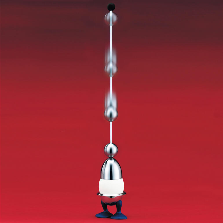 Ouvre-oeuf Clack en métal brillant, sur fond rouge.