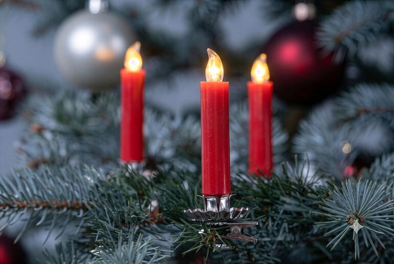 Bougies de Noël en cire véritable LED rouges sur un sapin.