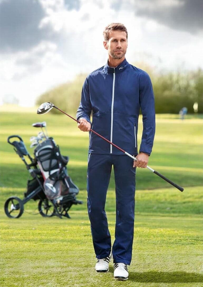 Homme en vêtements fonctionnels KJUS sur un terrain de golf.