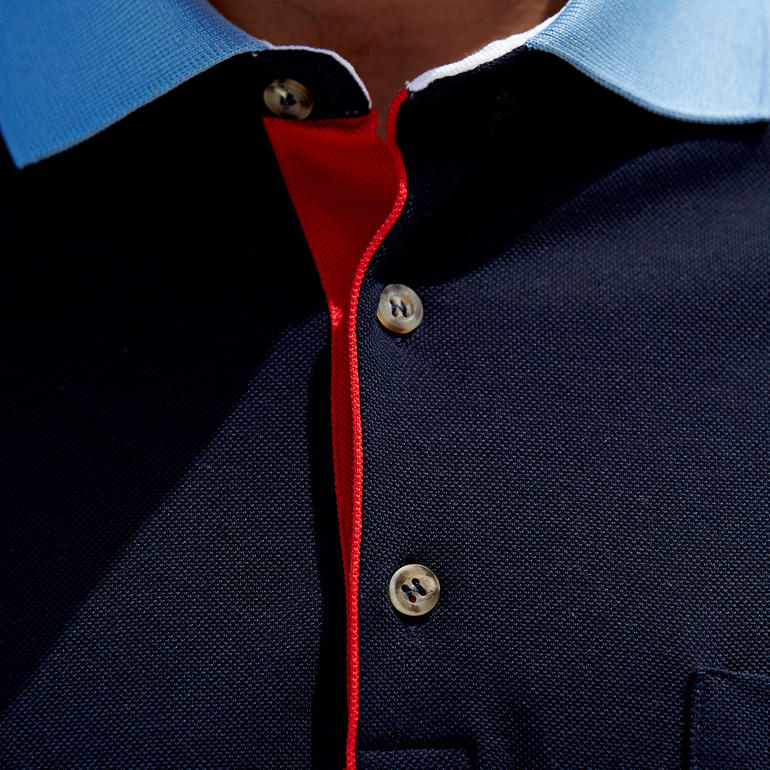 Gros plan du col d'un polo bleu foncé avec des accents rouges.