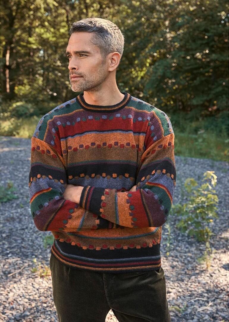 Homme en pull coloré dans un environnement vert.