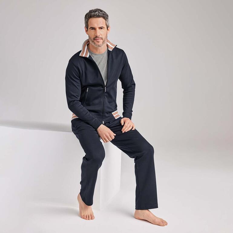 Homme en marine, assis sur le sol dans des vêtements décontractés.