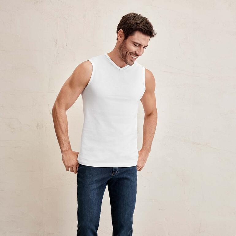 Homme en débardeur, souriant et regardant vers le bas