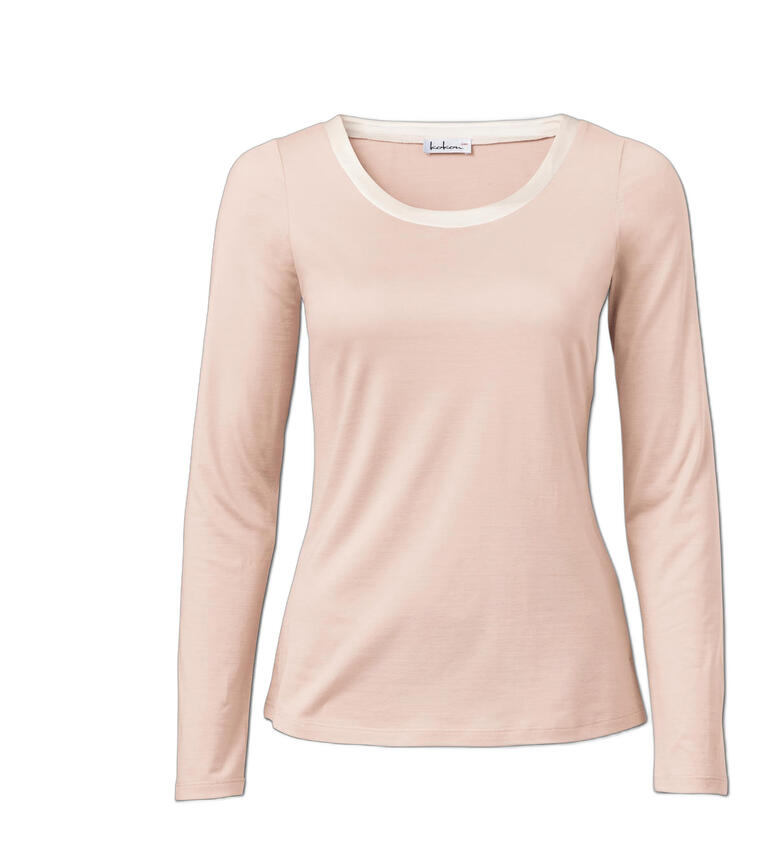 Haut en soie rose pâle avec manches longues et encolure ronde.