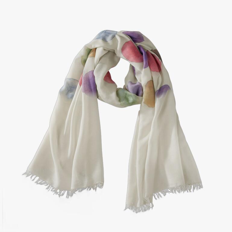 Écharpe à pois colorée en crème, rouge, violet et vert sur une table.