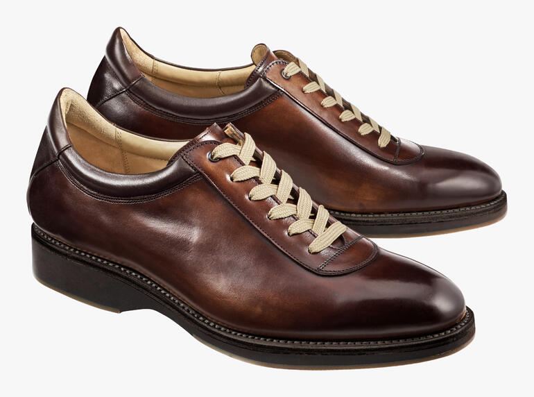 Deux Cordwainer Edelsneakers en marron sur fond clair.