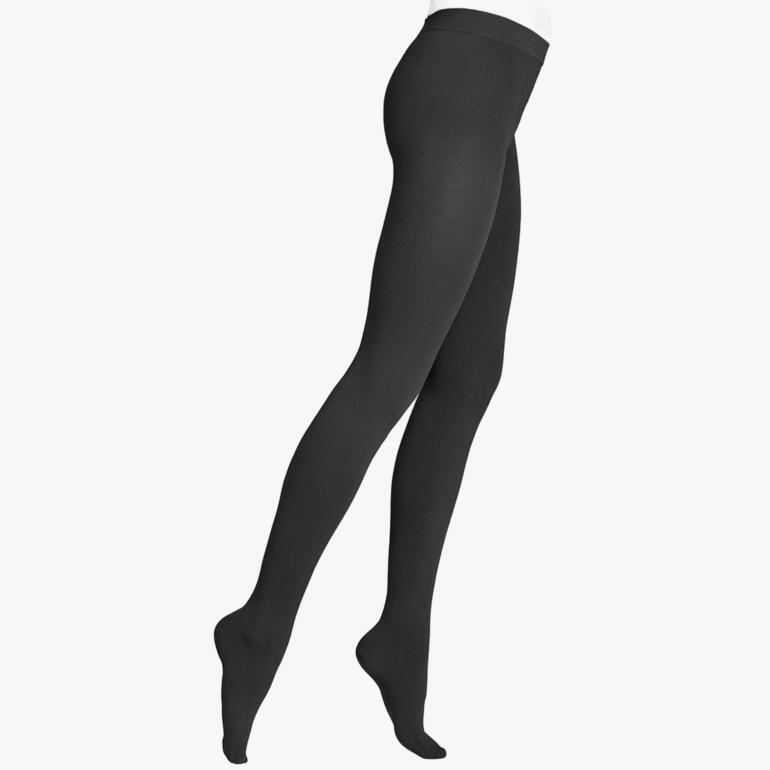Femme portant des collants de compression thermique noirs avec une jambe en l'air
