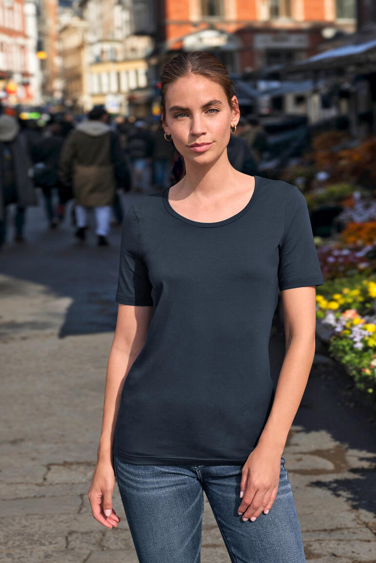 Femme portant un T-shirt marine à manches courtes dans une rue de ville.