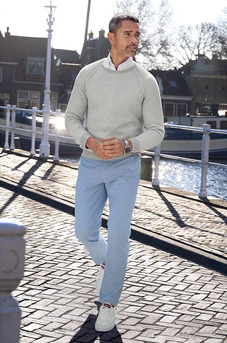 Gris/Blanc Homme portant un pull en tricot à motif Carbery gris au bord d'un canal.