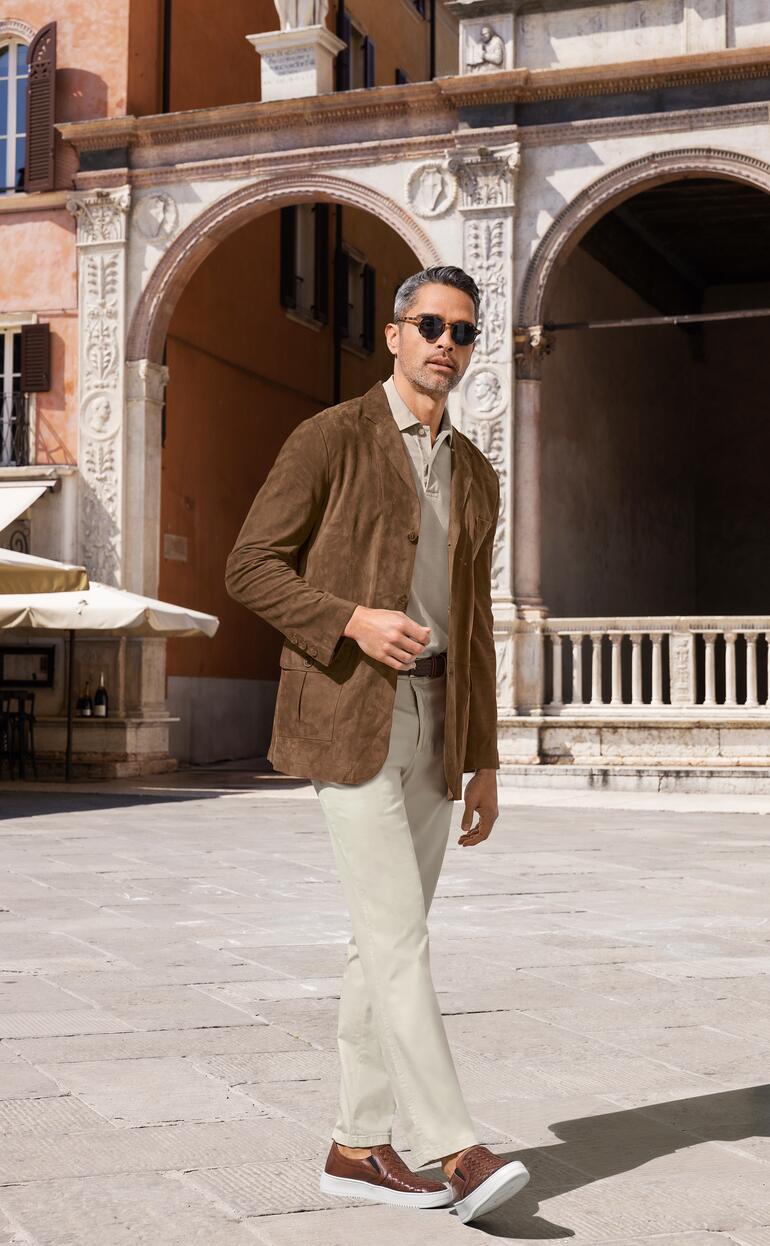 Veste lavable en chevreau suédé OCONI Homme portant une veste en suède de chèvre lavable marron dans un paysage urbain.