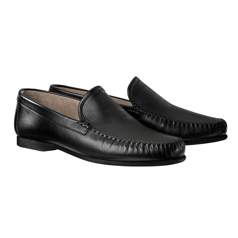 Une paire de mocassins noirs sur fond blanc.