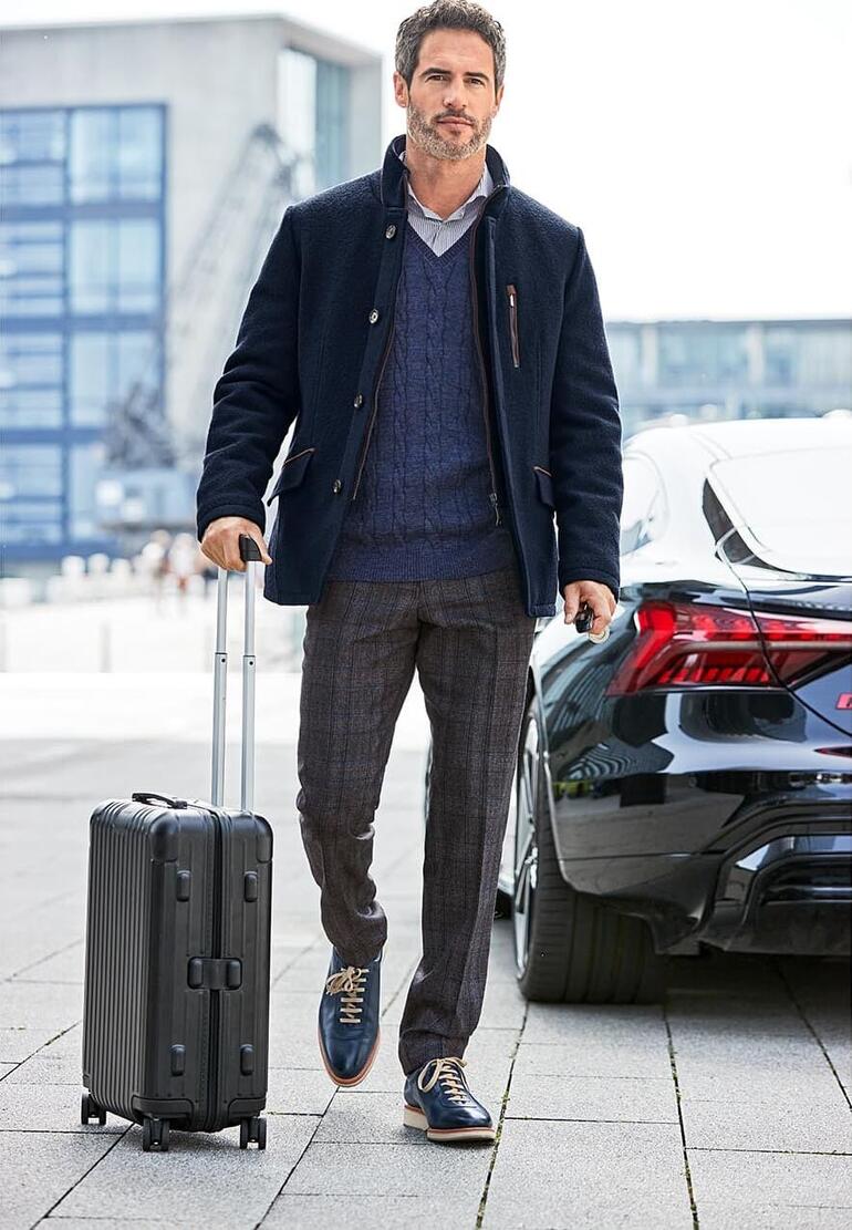 Veston en drap de laine foulée Homme en veste en feutre de laine dans un cadre urbain, avec une valise.