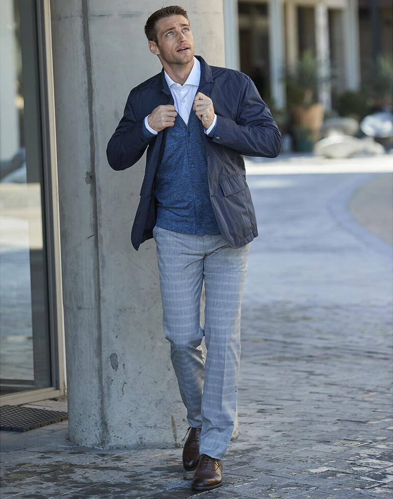 Homme dans un manteau de pluie de bureau, debout dans la rue.