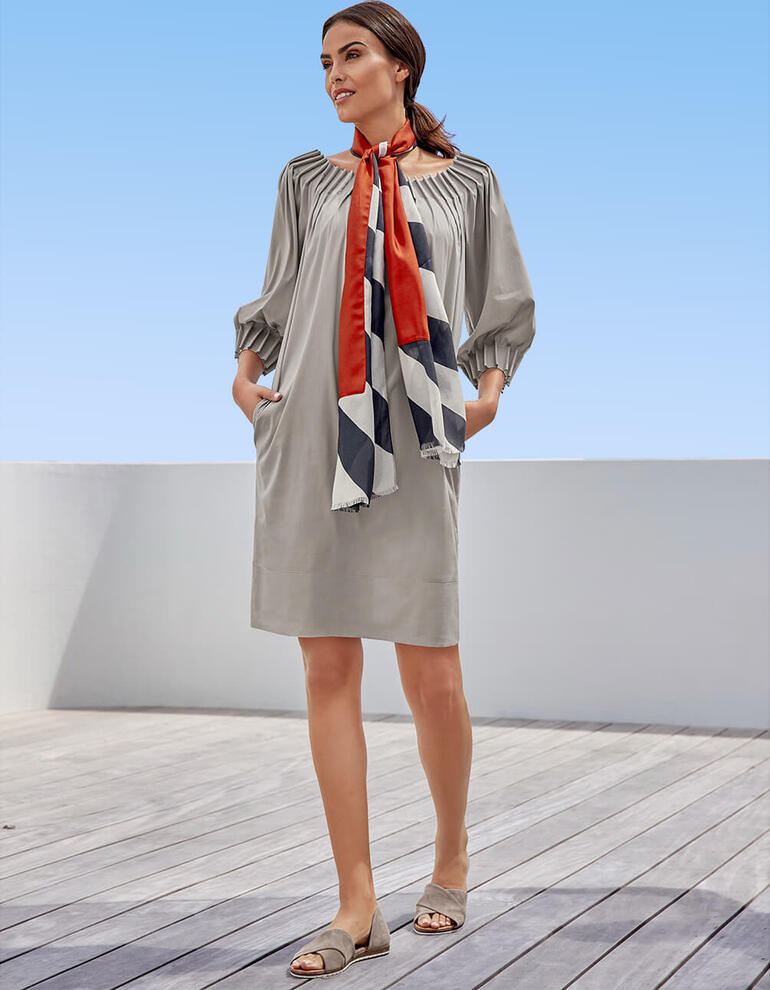 Gris Robe pour femme avec une écharpe colorée à la main sur la terrasse.
