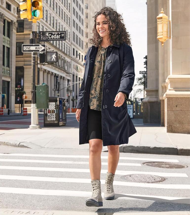 Femme en blouse batik à la mode et manteau de voyage dans la ville