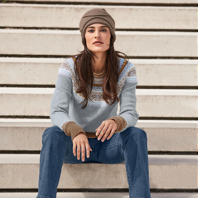 Taupe Femme assise sur les marches, portant un haut gris et un bandeau beige