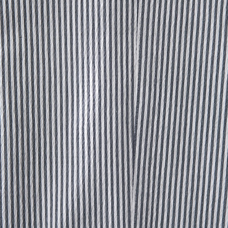 Blanc/Bleu Gros plan du tissu d'un pantalon en seersucker avec motif rayé