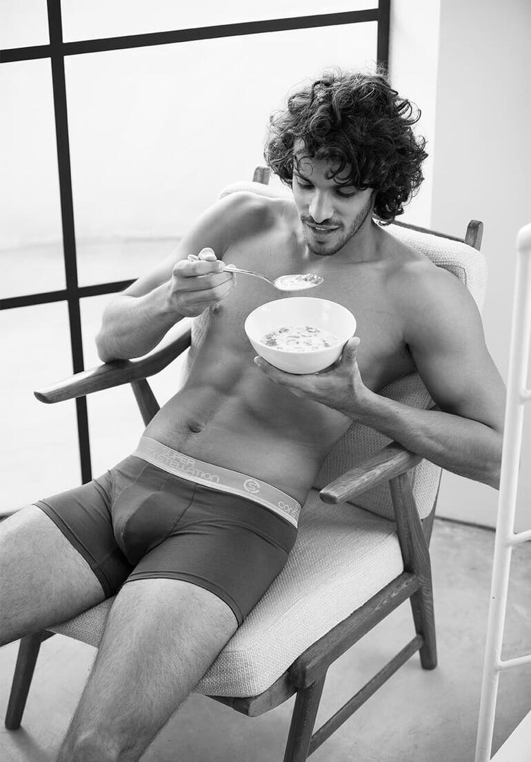 Short, Gris Homme en short boxer, prenant son petit déjeuner avec un bol de céréales.