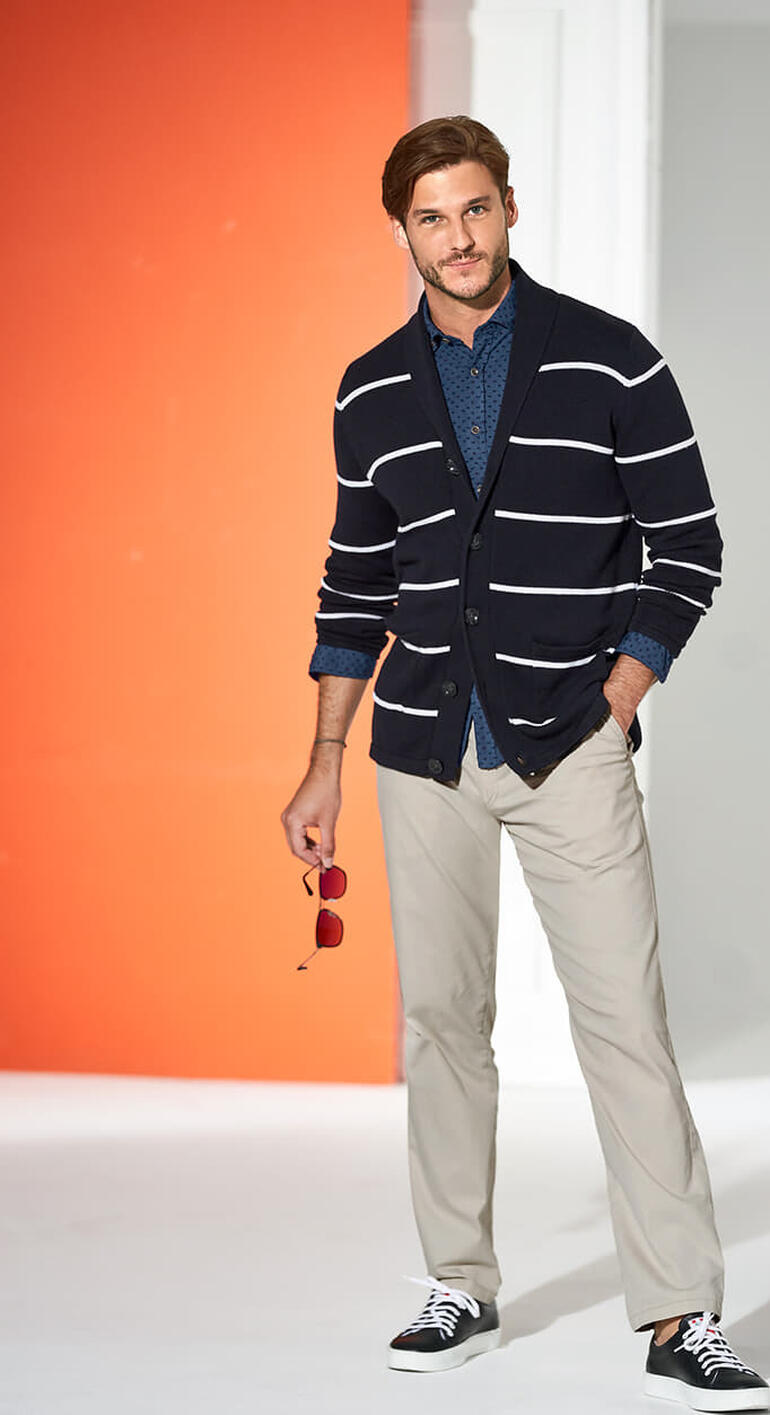 Homme en cardigan maritime à rayures, habillé décontracté.