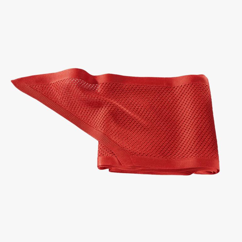 Écharpe en soie rouge tricotée sur fond blanc.