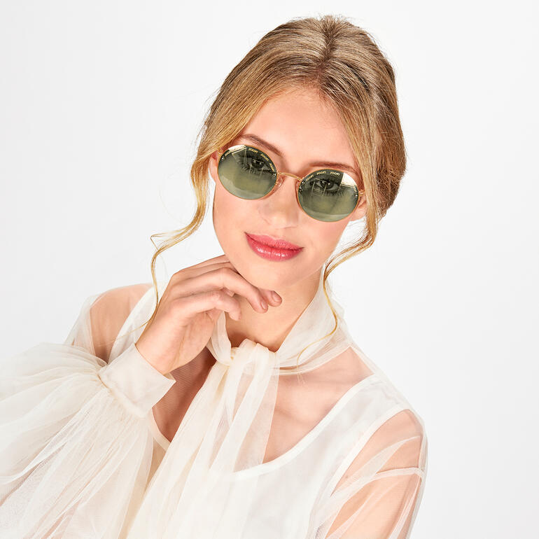 Femme portant des lunettes de soleil sans monture JOOP! et souriant.