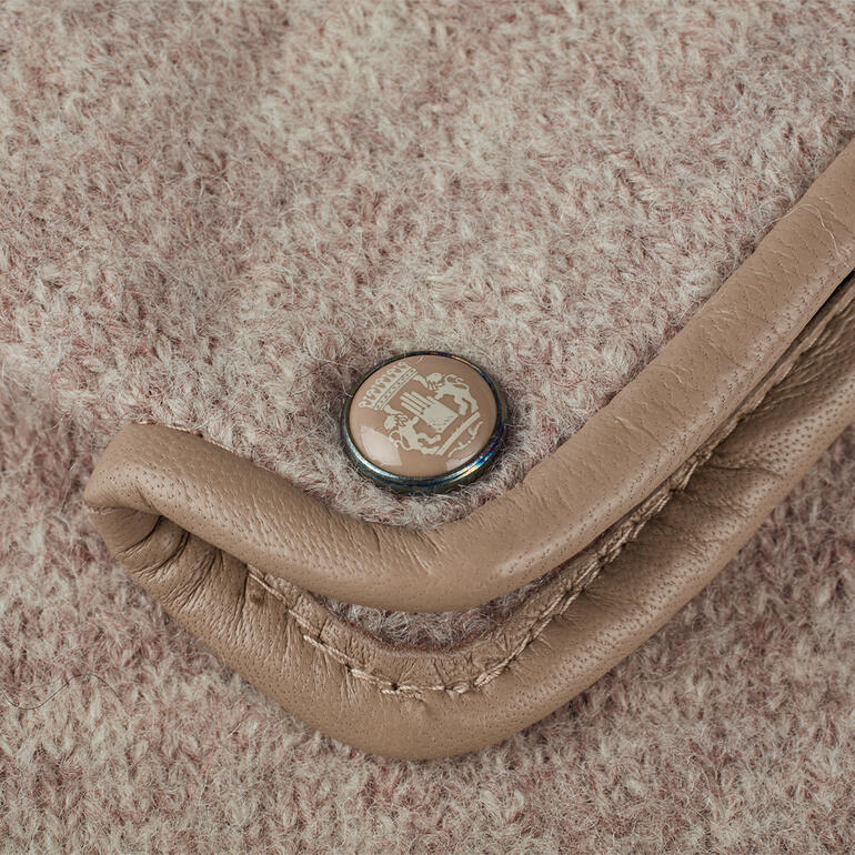 Gros plan détaillé d'un gant en feutre beige avec un bouton-pression.