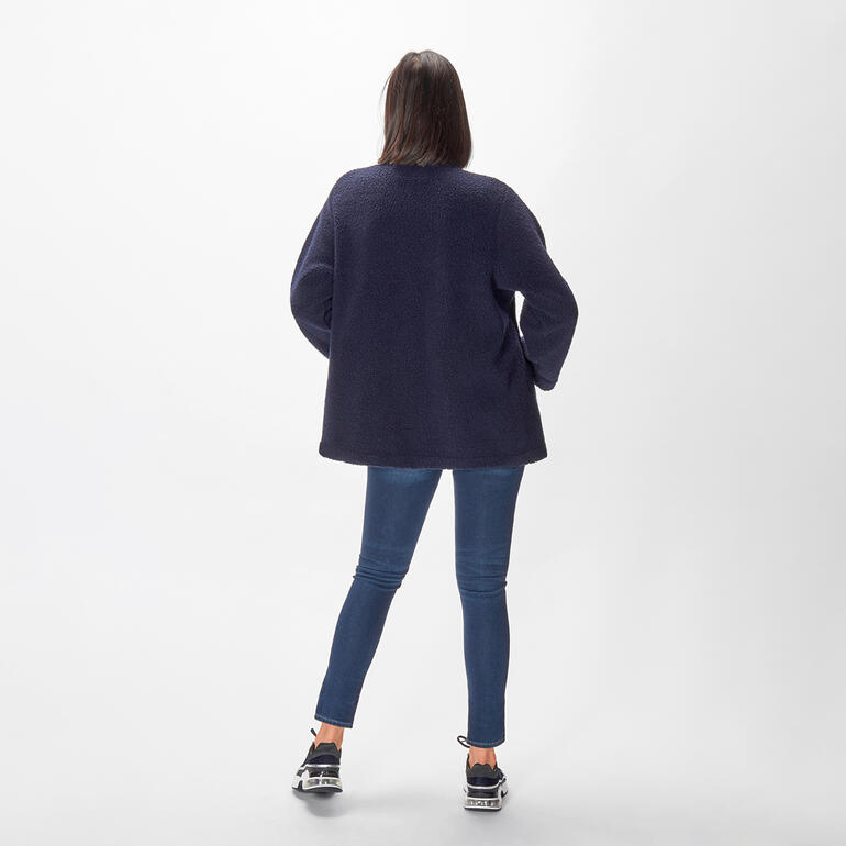 Veste bouclé bleu foncé vue de dos, portée par une femme en jeans.
