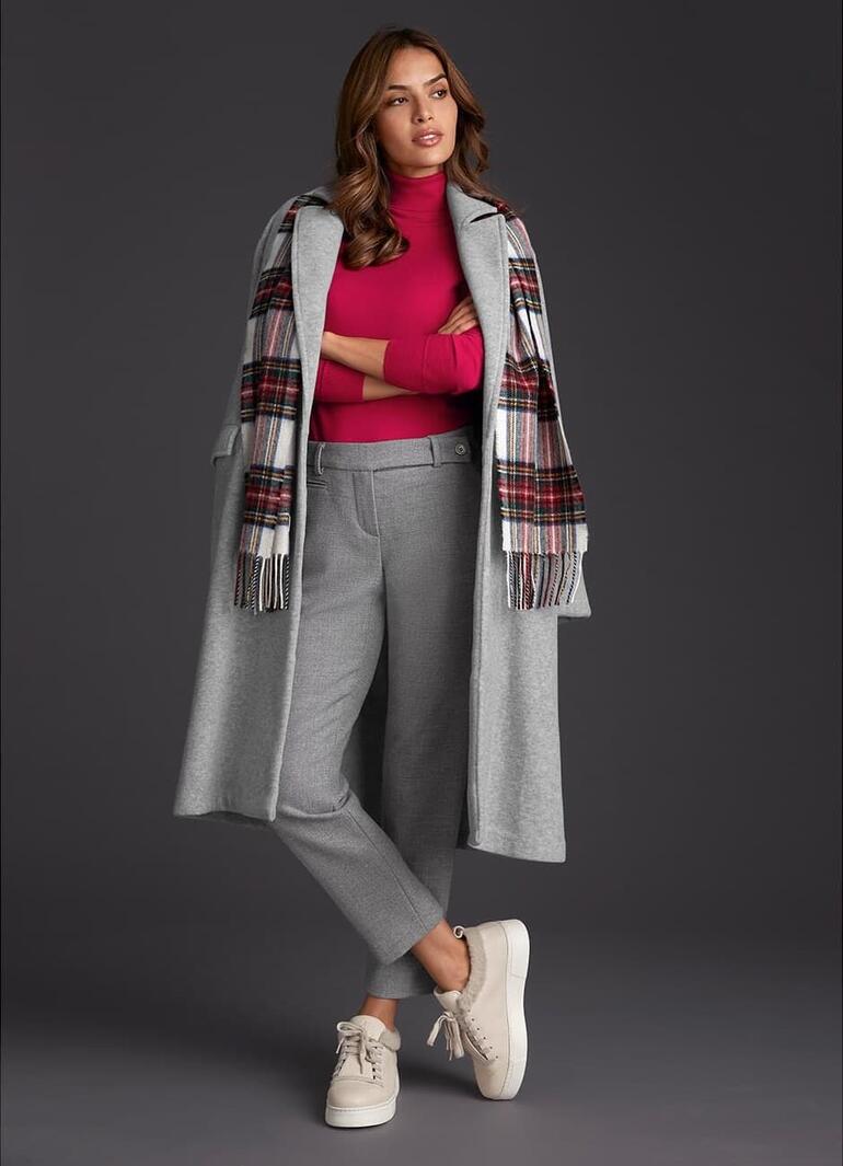 Femme en manteau en molleton gris Pluto regardant la caméra.