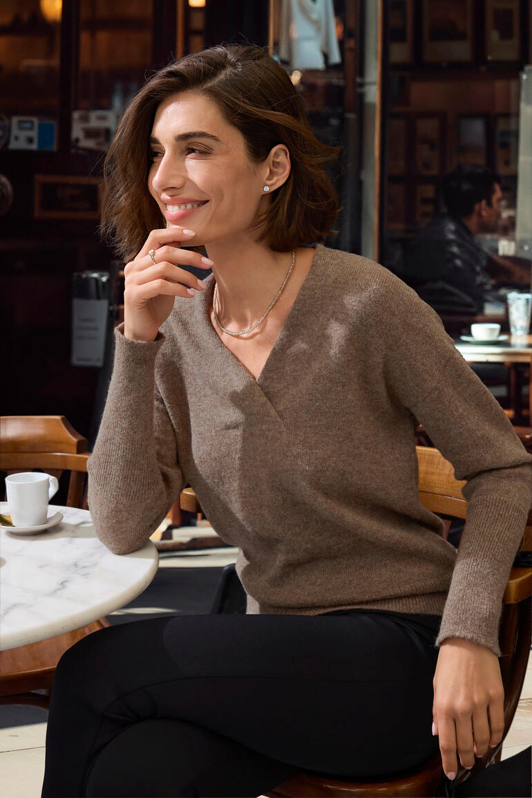 Pull en alpaga pour femmes en brun, souriante assise à la table.