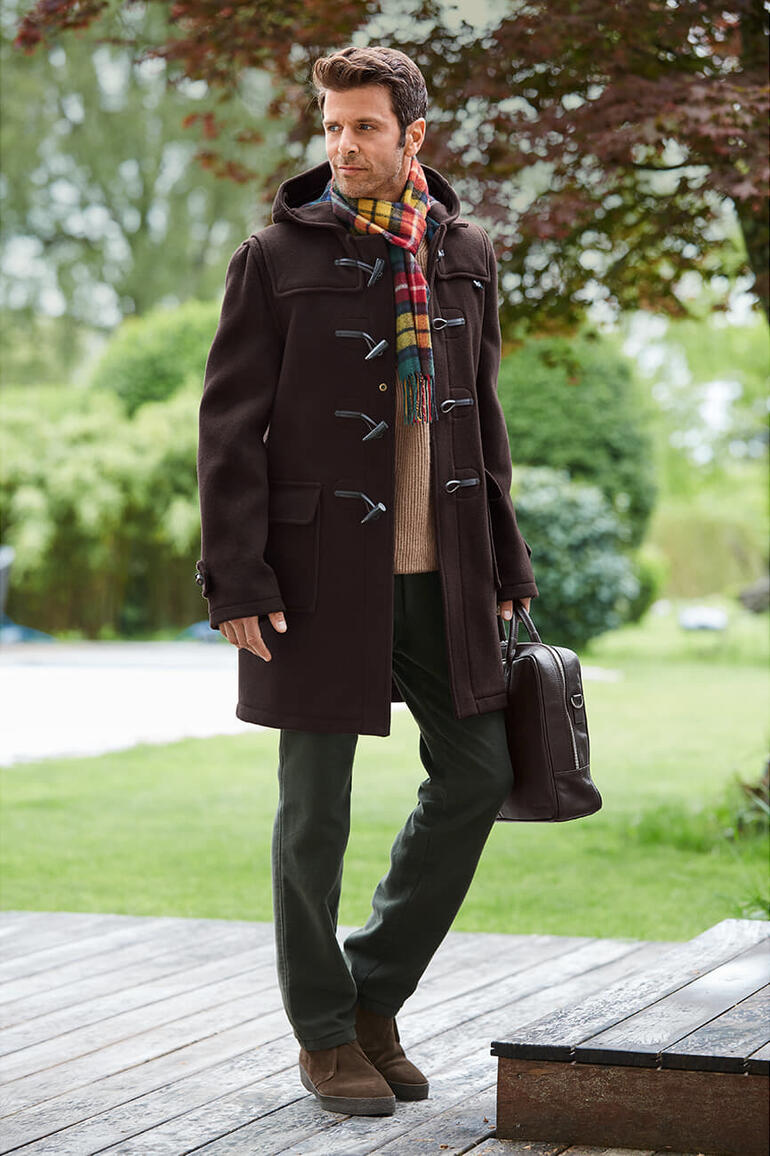 Homme portant un dufflecoat marron avec une poche et une écharpe à l'extérieur