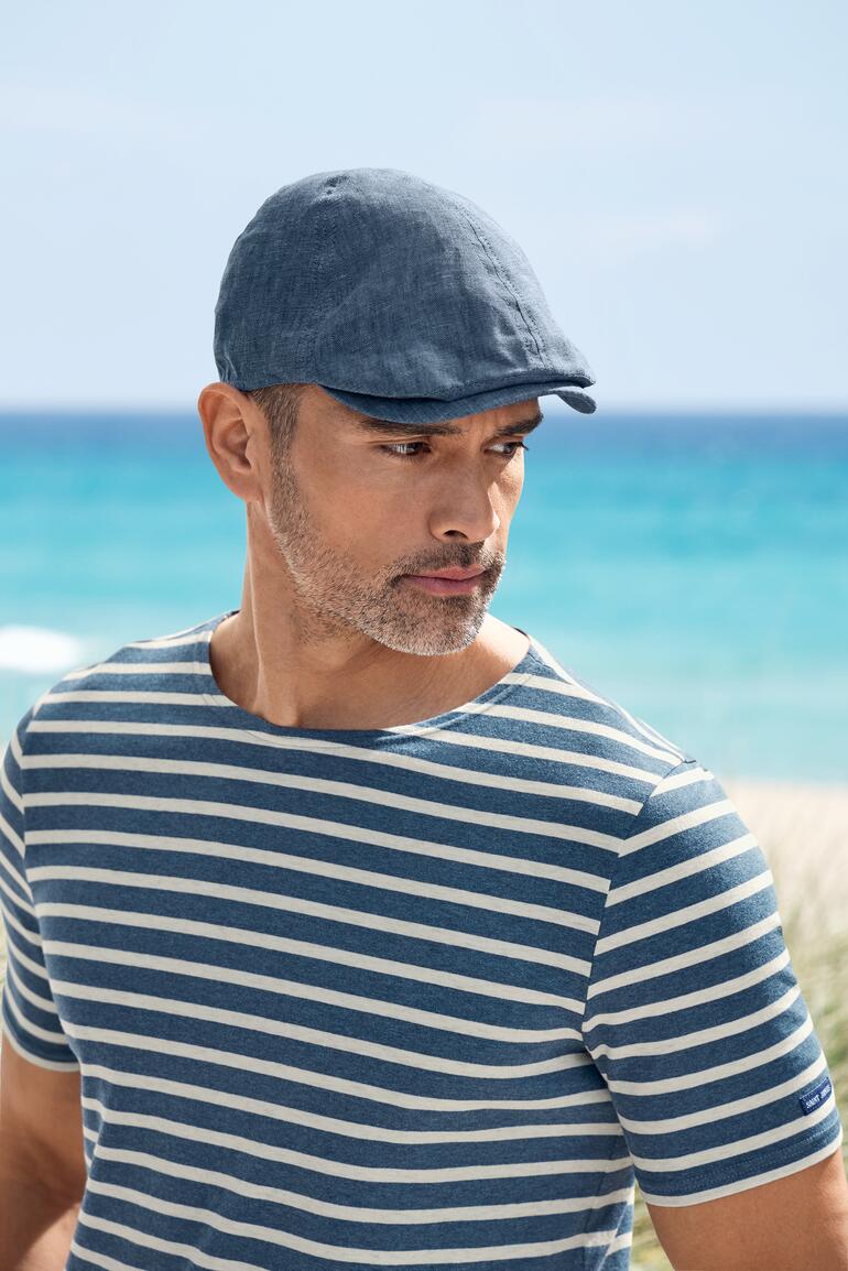 Portrait d'un homme portant une casquette en lin à la plage
