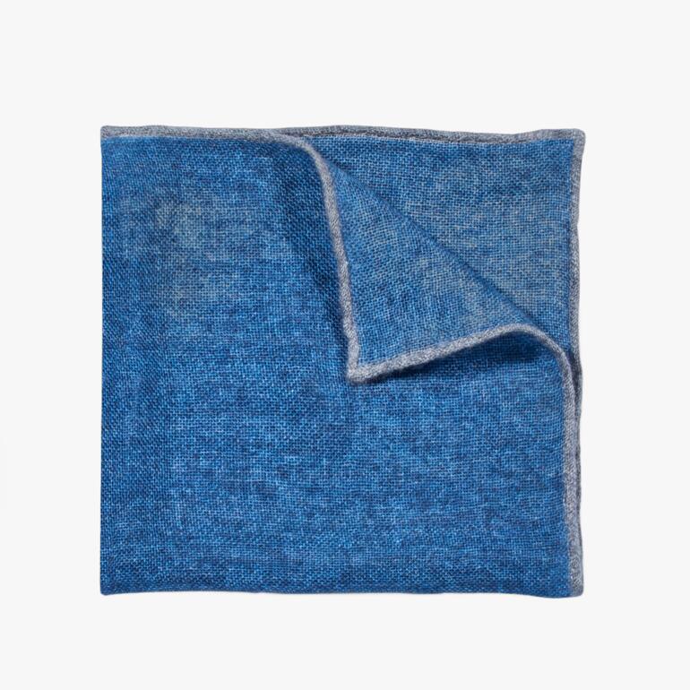 Pochette en cachemire bleue avec bord gris, sur fond blanc
