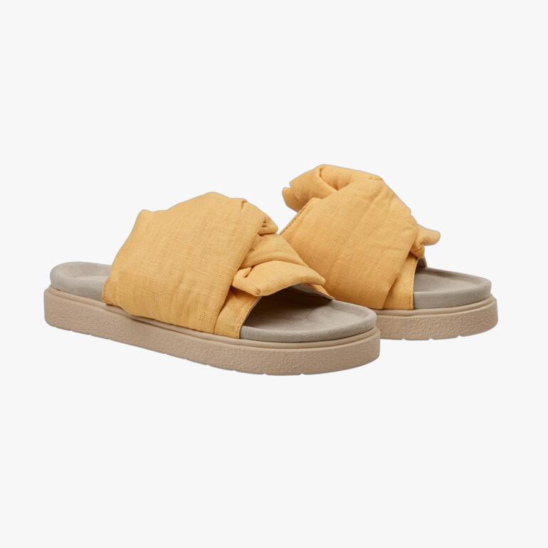 Nu-pantolette jaune d'Inuikii, vue latérale sur un fond neutre.