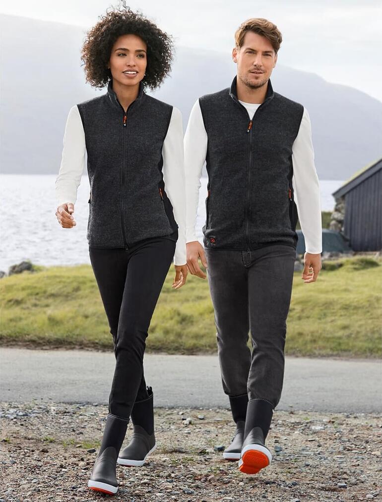 Couple marchant le long de l'eau, portant des bottes en néoprène Tretorn.