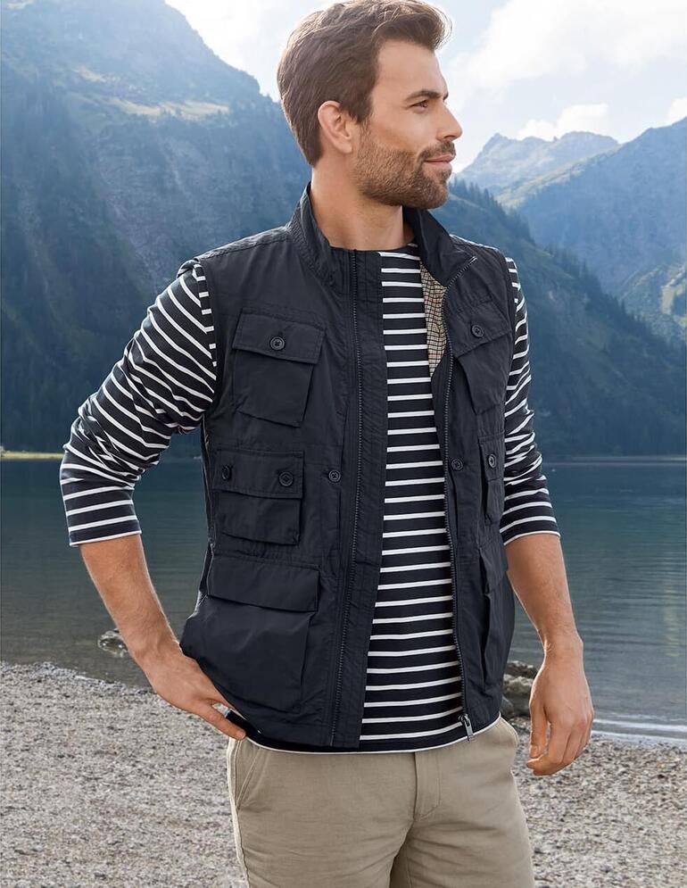 Homme en gilet à 10 poches noir regardant un lac de montagne.