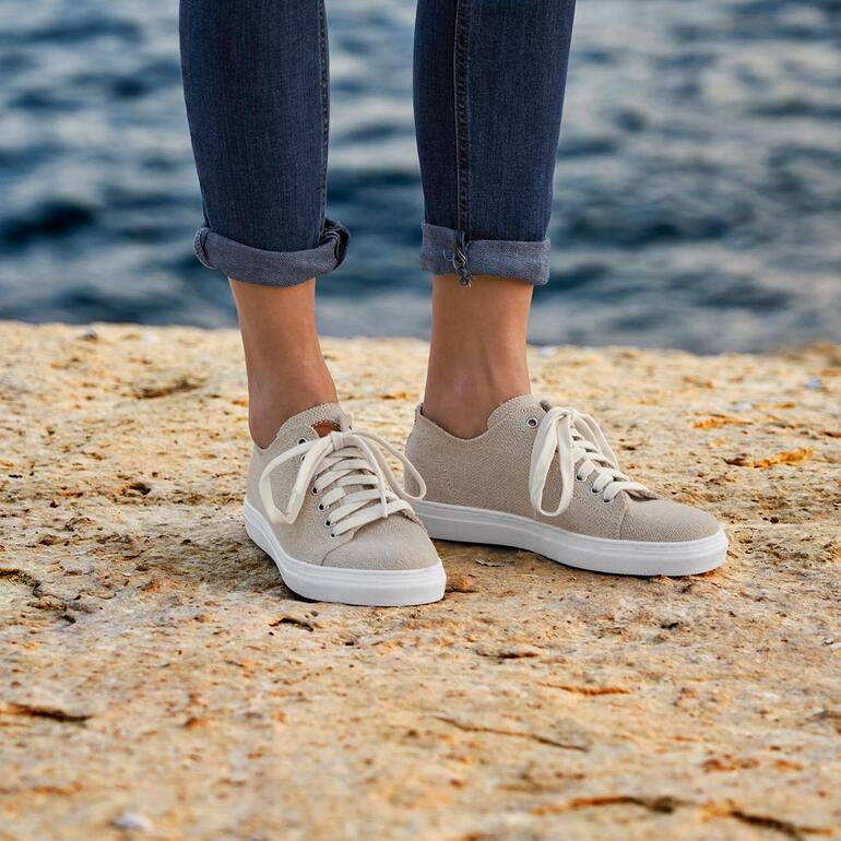 femme Baskets en chanvre Risorse Future beiges aux pieds sur un rivage