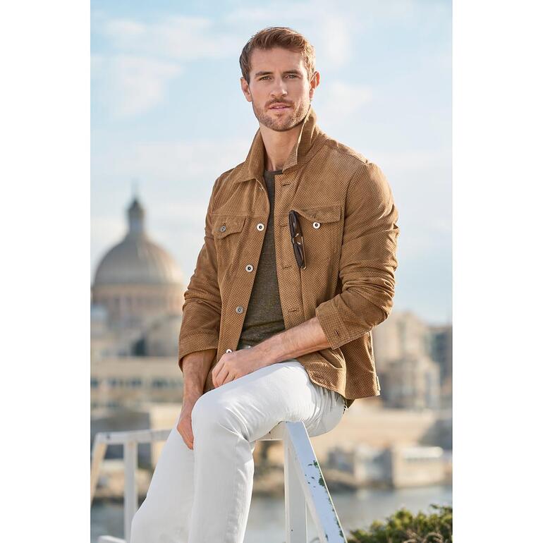 Veste en cuir style jean perforée Homme en veste en cuir perforée avec un pantalon blanc.