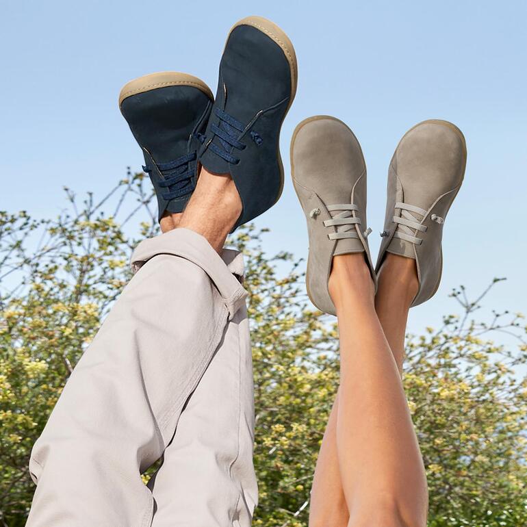 Chaussures en cuir pieds-nus Snipe® Pieds dans des chaussures en cuir Snipe® barfoor noires et grises, arrière-plan décontracté