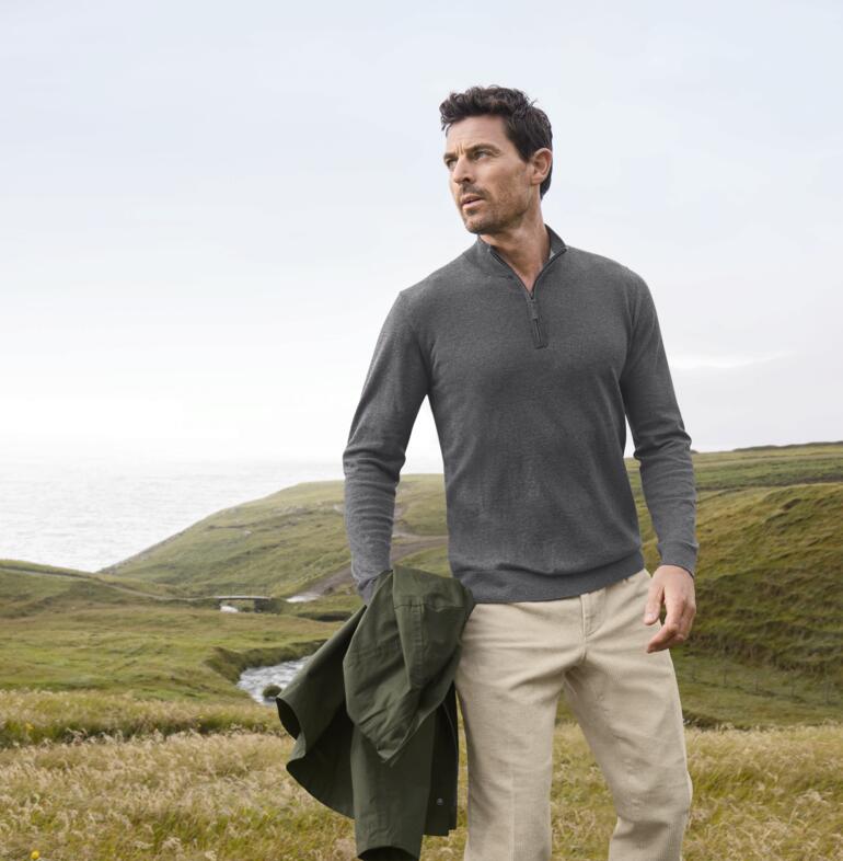 Homme portant un troyer Alan Paine gris toute saison avec un paysage en arrière-plan.